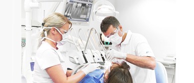 Dr. Kőhalmi Tamás és asszisztense egy pácienst kezelnek a Dentalux Fogászat kecskeméti rendelőjében